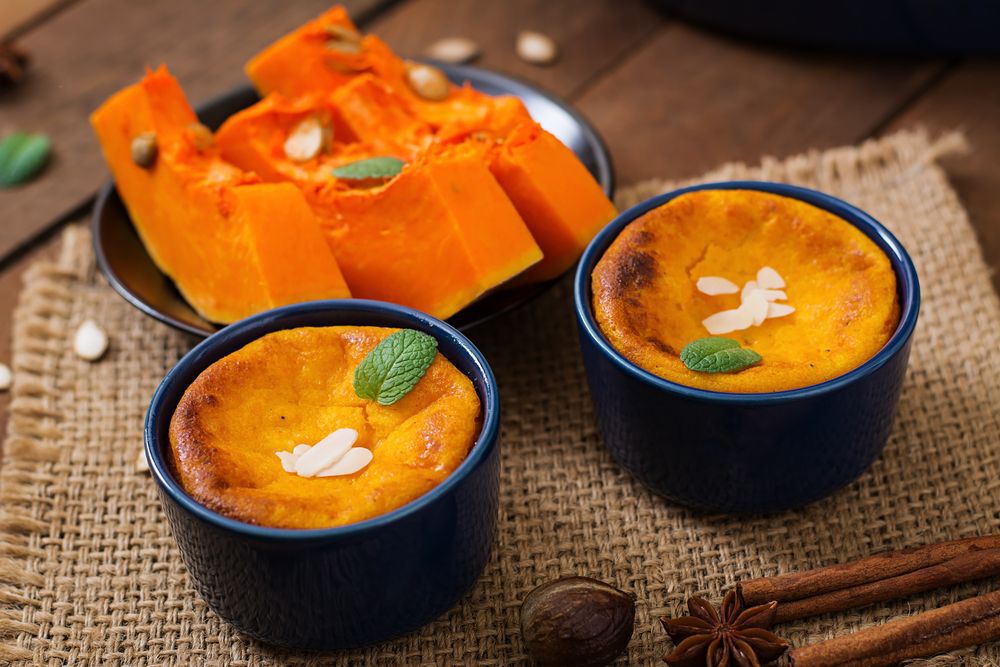 Cottage cheese and pumpkin pudding with cinnamon and nutmeg on wooden background