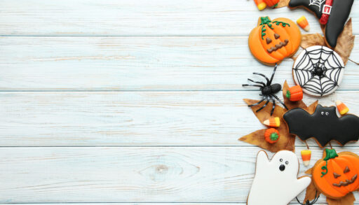 Halloween-themed gingerbread cookies decorated as pumpkins, ghosts, bats and spiderwebs.