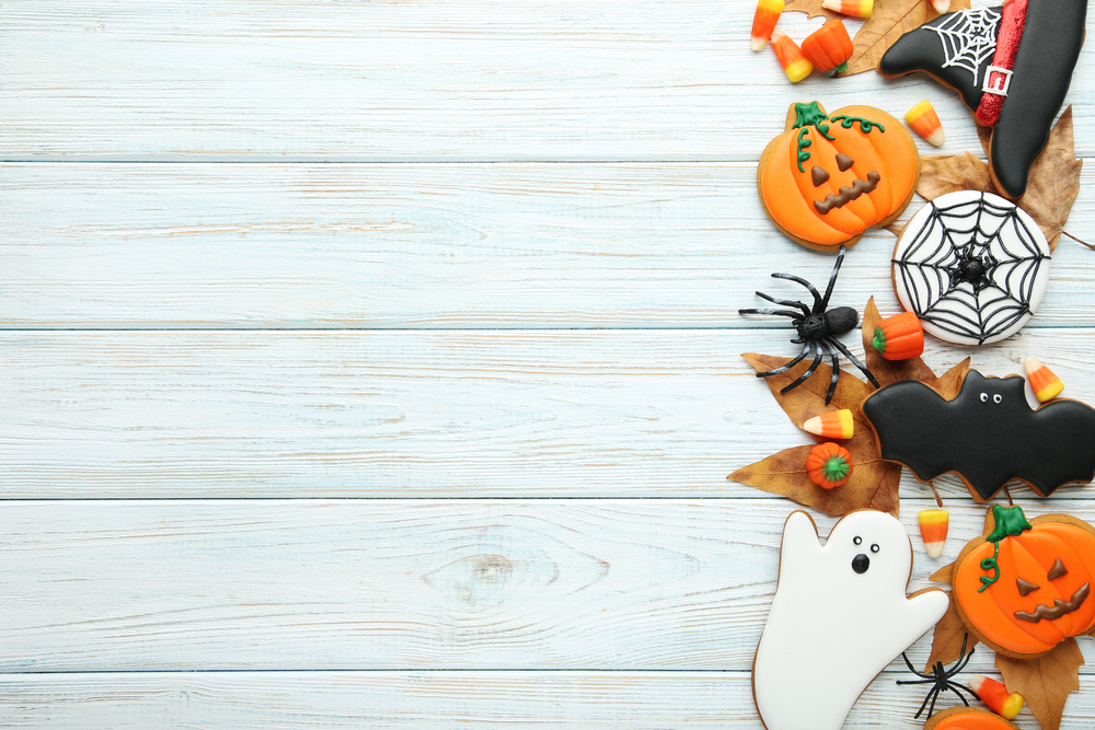 Halloween-themed gingerbread cookies decorated as pumpkins, ghosts, bats and spiderwebs.