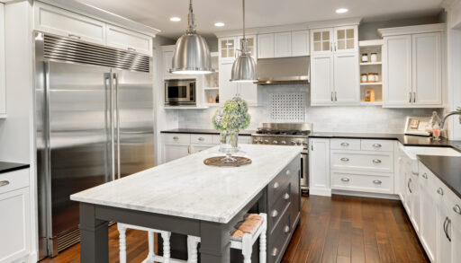Interior of a modern kitchen with a large silver fridge and grey island.