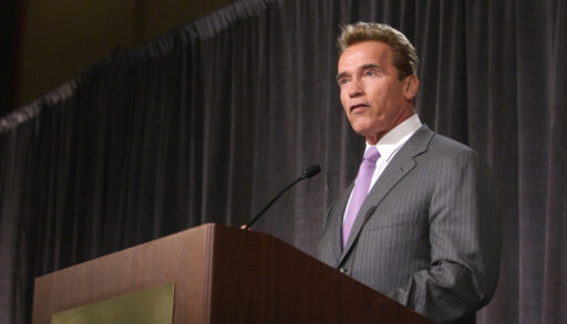 Arnold Schwarzenegger speaking behind a podium.