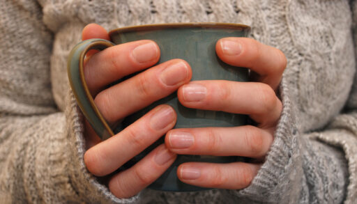 Close-up of a woman's hands holding a blue-grey coloured mug.