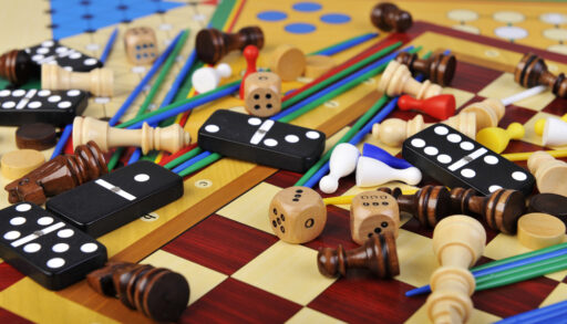 Close-up of various board game pieces such as dominos, dice and chess pawns.