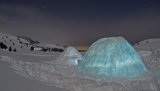 Illuminated igloo at night.