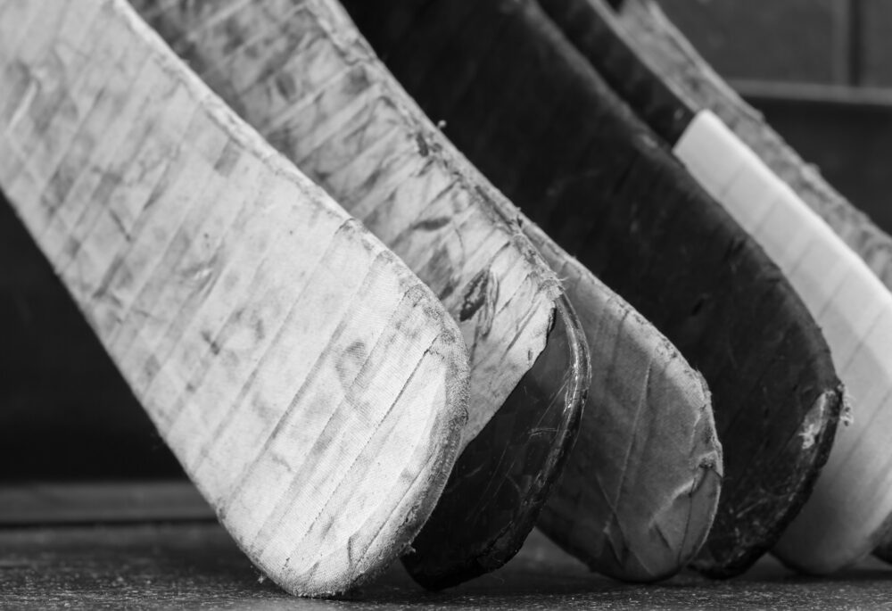 Close-up of taped hockey stick blades.