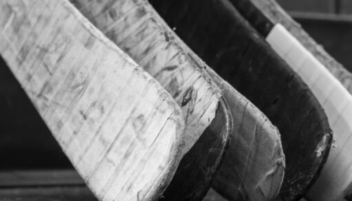 Close-up of taped hockey stick blades.