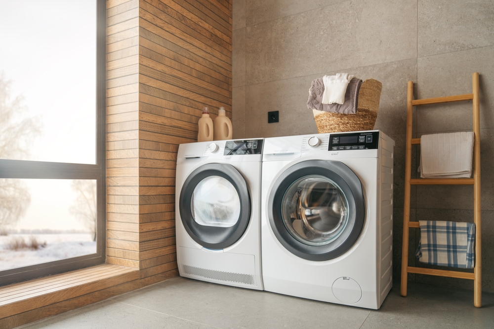 Interior of a laundry room with wood slats on one wall and white washer and dryer.