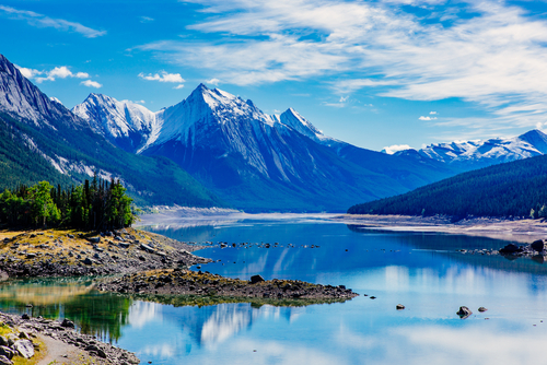 Medicine Lake surrounded by snow-covered mountains in Jasper National Park, Alberta, Canada.