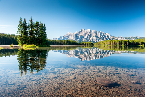 Mount Rundle illuminated by the sun next to Cascade Ponds Lake, Banff National Par, Alberta, Canada.