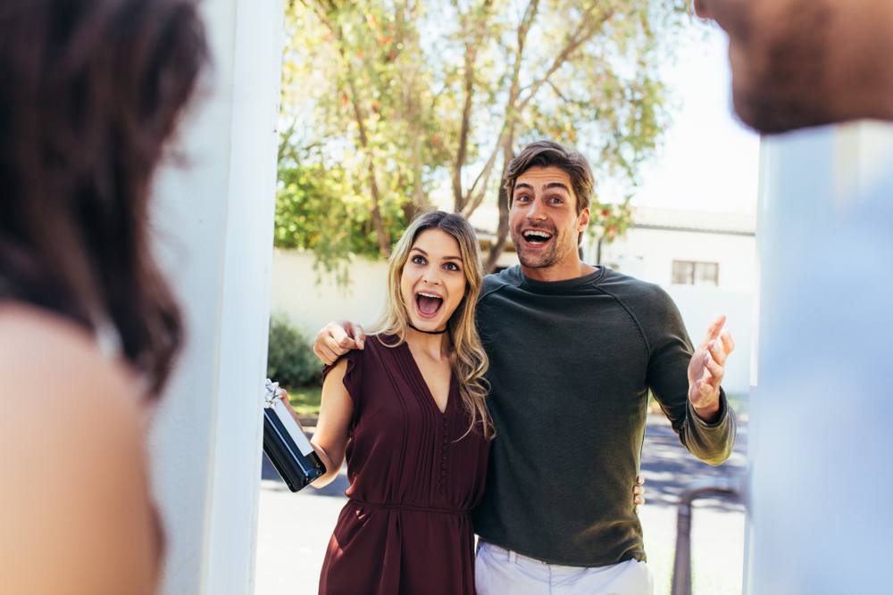 Young man and woman arriving at a friend's house.