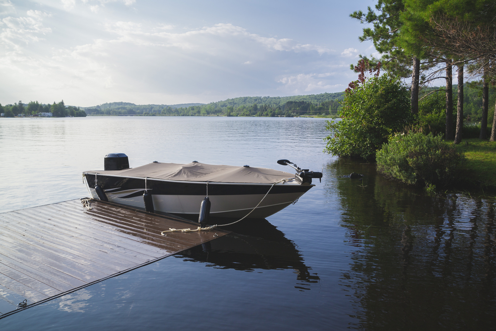 Motor boat anchored to a dock on a lake.