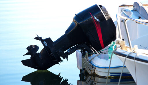 Black boat engine attached to the back of a boat.