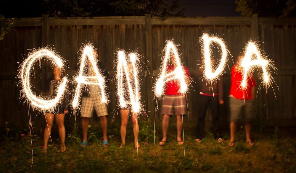 People hold up sparklers spelling "Canada".