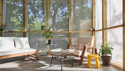 Light screened-in porch with mid-century modern furniture.