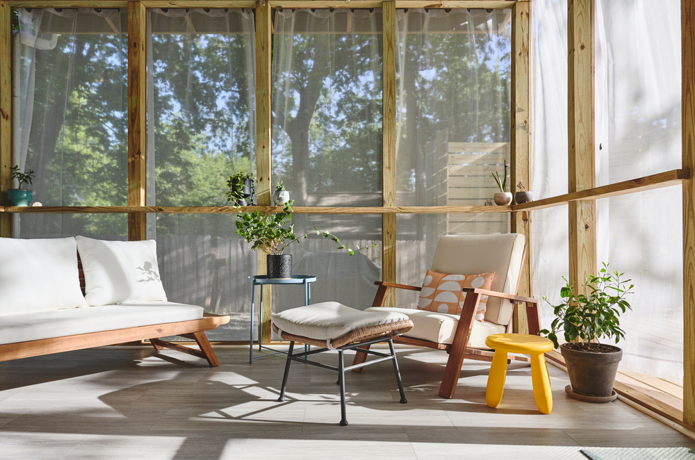 Light screened-in porch with mid-century modern furniture.