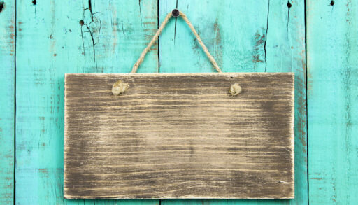 Blank wooden sign on a turquoise wood background.