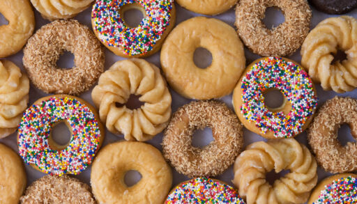 Overhead view of rows of different types of donuts.