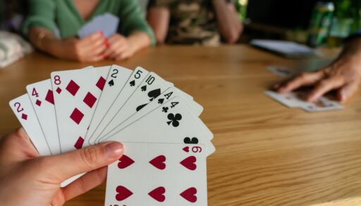 Close-up of a person holding cards and playing a card game.