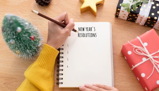 Top-view of a woman writing New Year's resolution on a list.