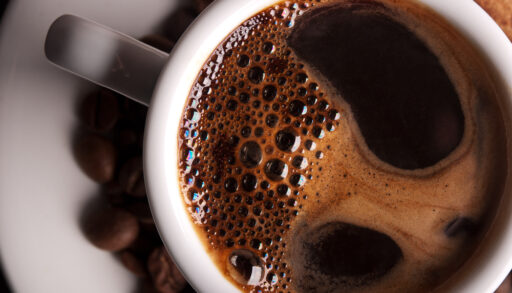 Close-up of dark-coloured coffee in a white mug.