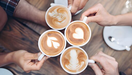 Overhead view of four people drinking different types of coffee.