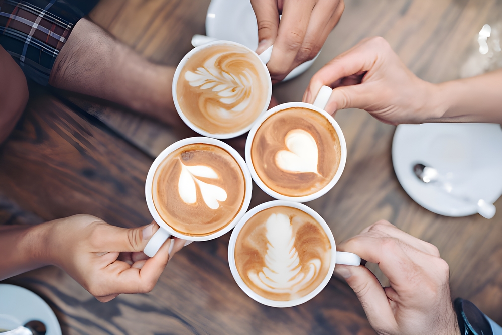 Overhead view of four people drinking different types of coffee.