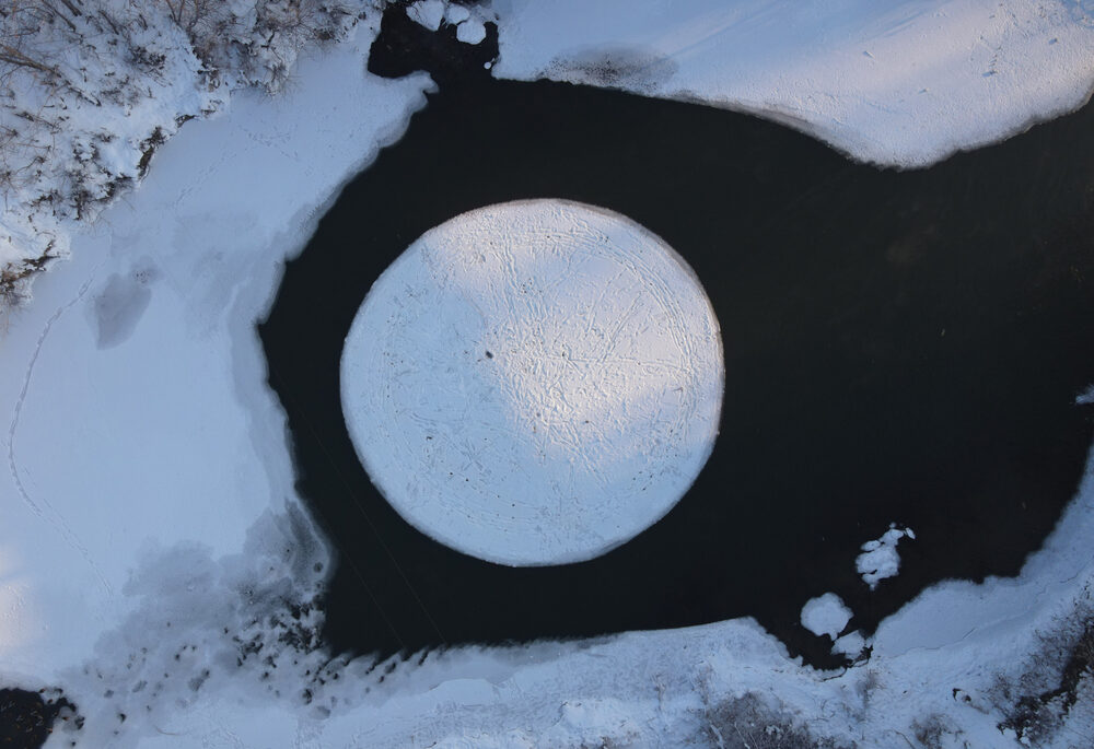 Overhead view of an ice circle in the middle of a lake.