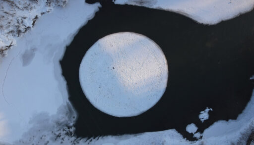 Overhead view of an ice circle in the middle of a lake.