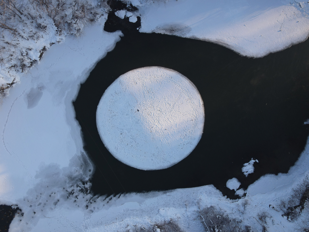 Overhead view of an ice circle in the middle of a lake.