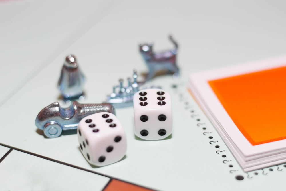 Close-up of dice and Monopoly game pieces.
