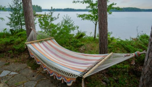 Close-up of a striped hammock next to a lake.