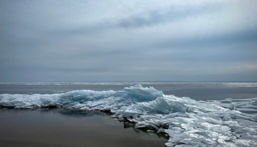 Blue, frozen waves on the shore of a beach.