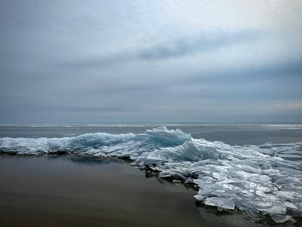 Blue, frozen waves on the shore of a beach.