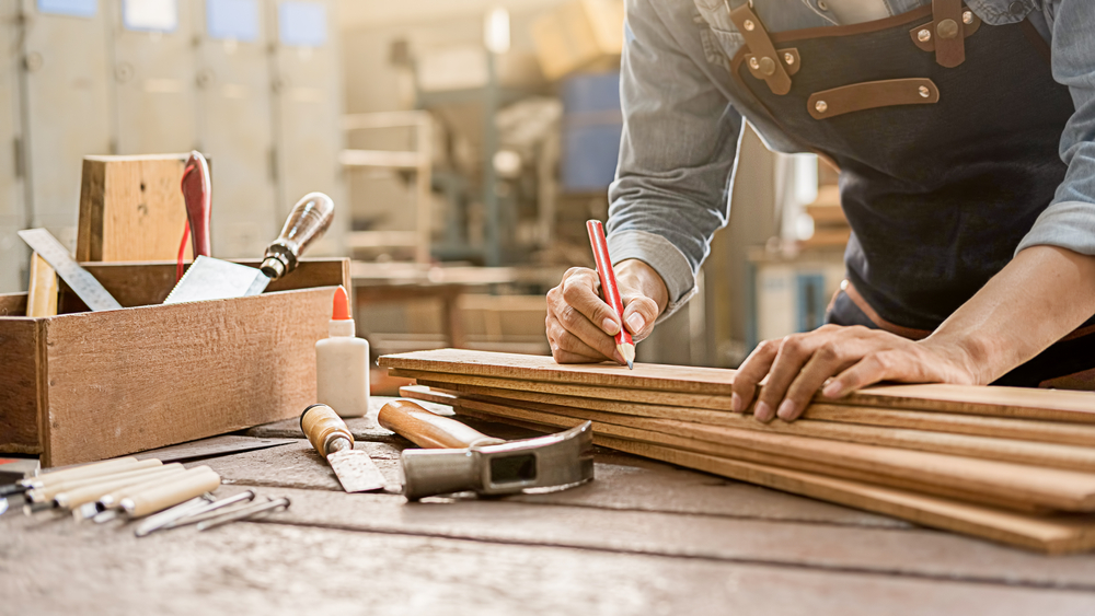 Close-up of a carpenter measuring wood.