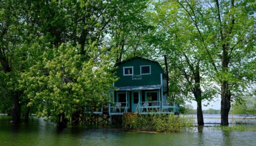 Green cottage on stilts during spring flooding in Sorel, Quebec.