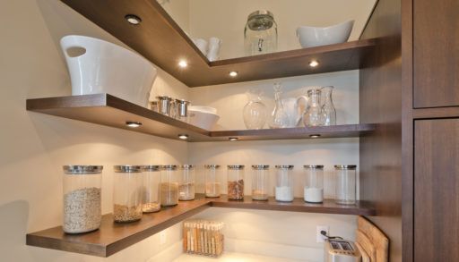Brown kitchen shelving with differently sized jars and containers.