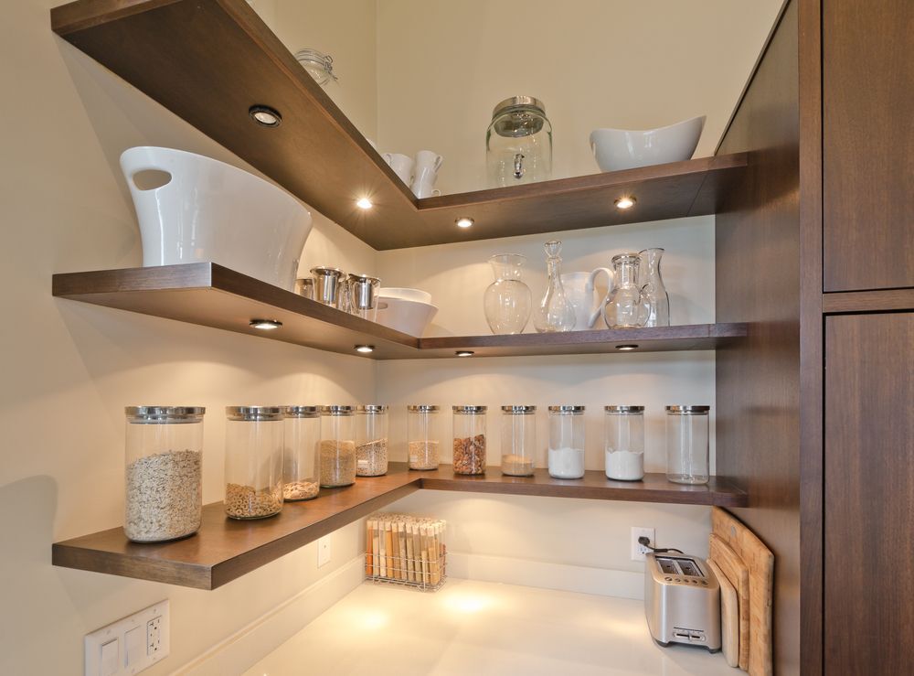 Brown kitchen shelving with differently sized jars and containers.