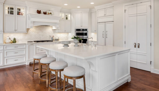 Modern, white kitchen with dark-coloured wooden floors.