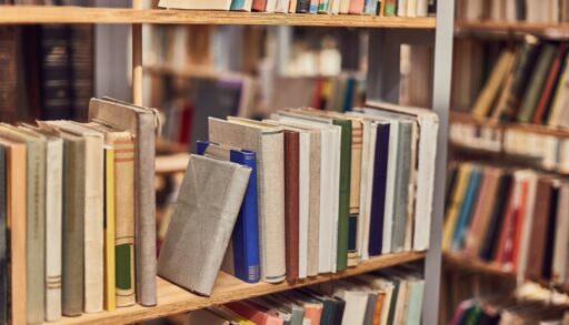 Books stacked on a bookshelf in a bookstore.