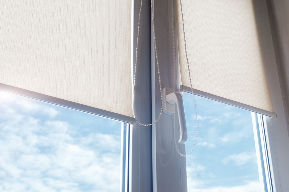 Close-up of windows with white roller blinds.