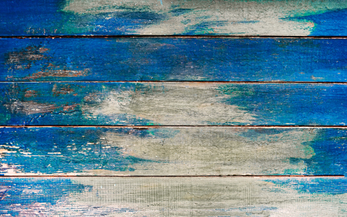 Close-up of driftwood boards painted with the colours of the ocean.