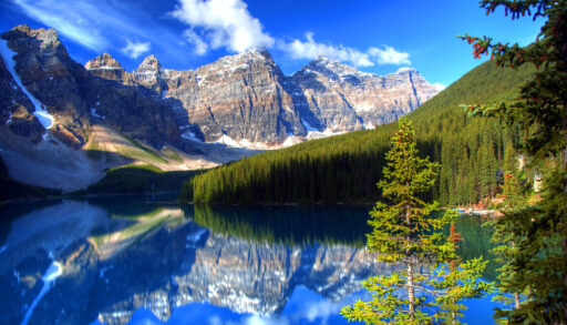 Reflections of mountains and trees in Moraine Lake, Alberta.