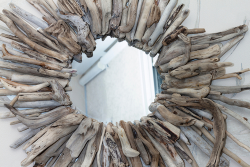 Close-up of a mirror with a frame made of driftwood.