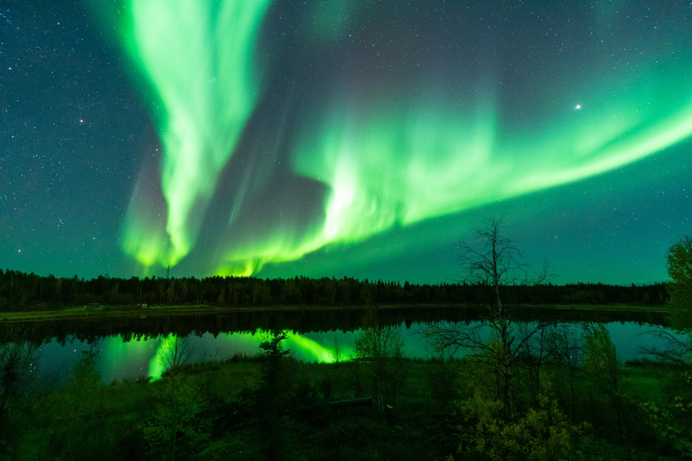Green Aurora Borealis over a lake in Yellowknife, Northwest Territories.