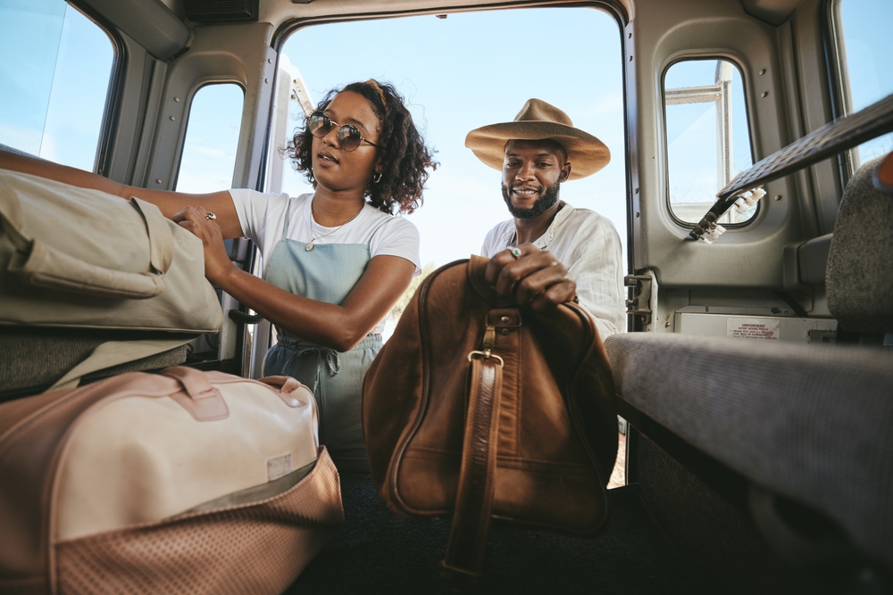 Man and woman packing luggage into a car.