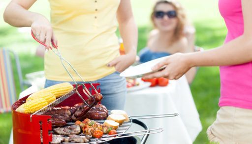 Close-up of a woman serving a grilled sausage.