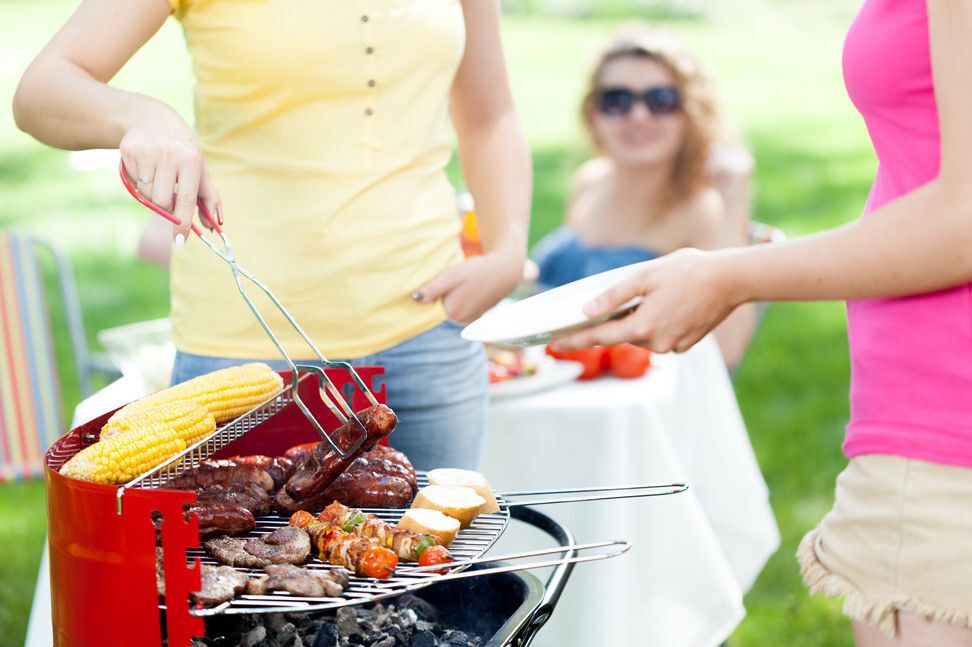 Close-up of a woman serving a grilled sausage.