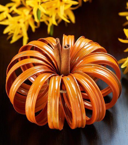 Jar lids tied together to make a pumpkin shape.