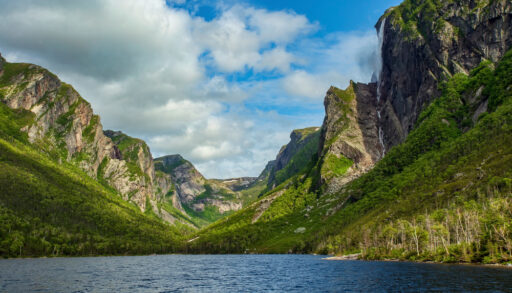 Grass-covered mountains surrounding Pissing Mare Falls in Gros-Morne National Park, Newfoundland.