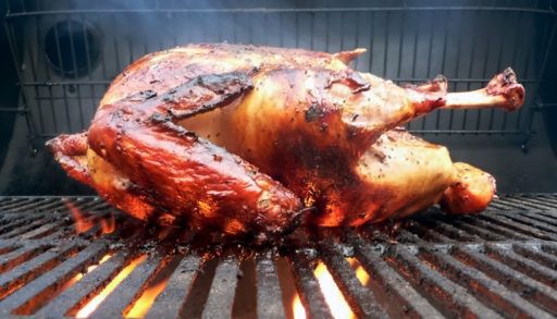 Close-up of a turkey cooking on a grill.